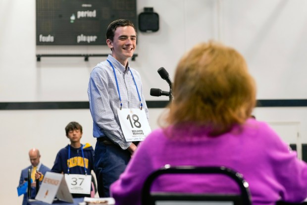 Benjamin Reinhard, 14, from Maranatha Christian School, listens to pronouncer Patricia Elmore Costa. (Nelvin C. Cepeda / The San Diego Union-Tribune)