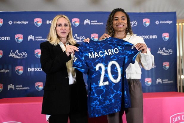 Catarina Macario, right, holds up her jersey with Camille Ashton, Sporting Director and General Manager, at a news conference held to announceher signing with the San Diego Wave FC March 27, 2026 in San Diego, Calif. (Photo by Denis Poroy)