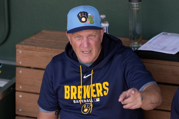 Milwaukee Brewers' Pat Murphy talks with coaches in the team dugout during the fifth inning of a spring training baseball game against the Athletics Tuesday, Feb. 24, 2026, in Mesa, Ariz. (AP Photo/Ross D. Franklin)