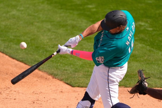 Seattle Mariners' Josh Naylor hits an RBI single during the third inning of a spring training baseball game against the San Diego Padres, Friday, Feb. 20, 2026, in Peoria, Ariz. (AP Photo/Charlie Riedel)