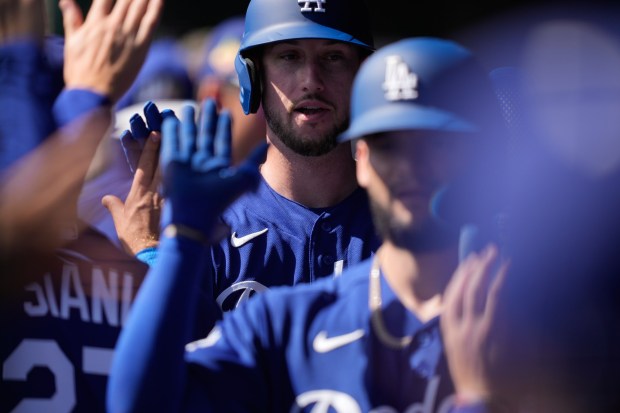 Los Angeles Dodgers' Kyle Tucker (23) and Andy Pages (44) both celebrate scoring in the second inning during spring training baseball game against the Cleveland Guardians, Tuesday, Feb. 24, 2026, in Phoenix. (AP Photo/Brynn Anderson)