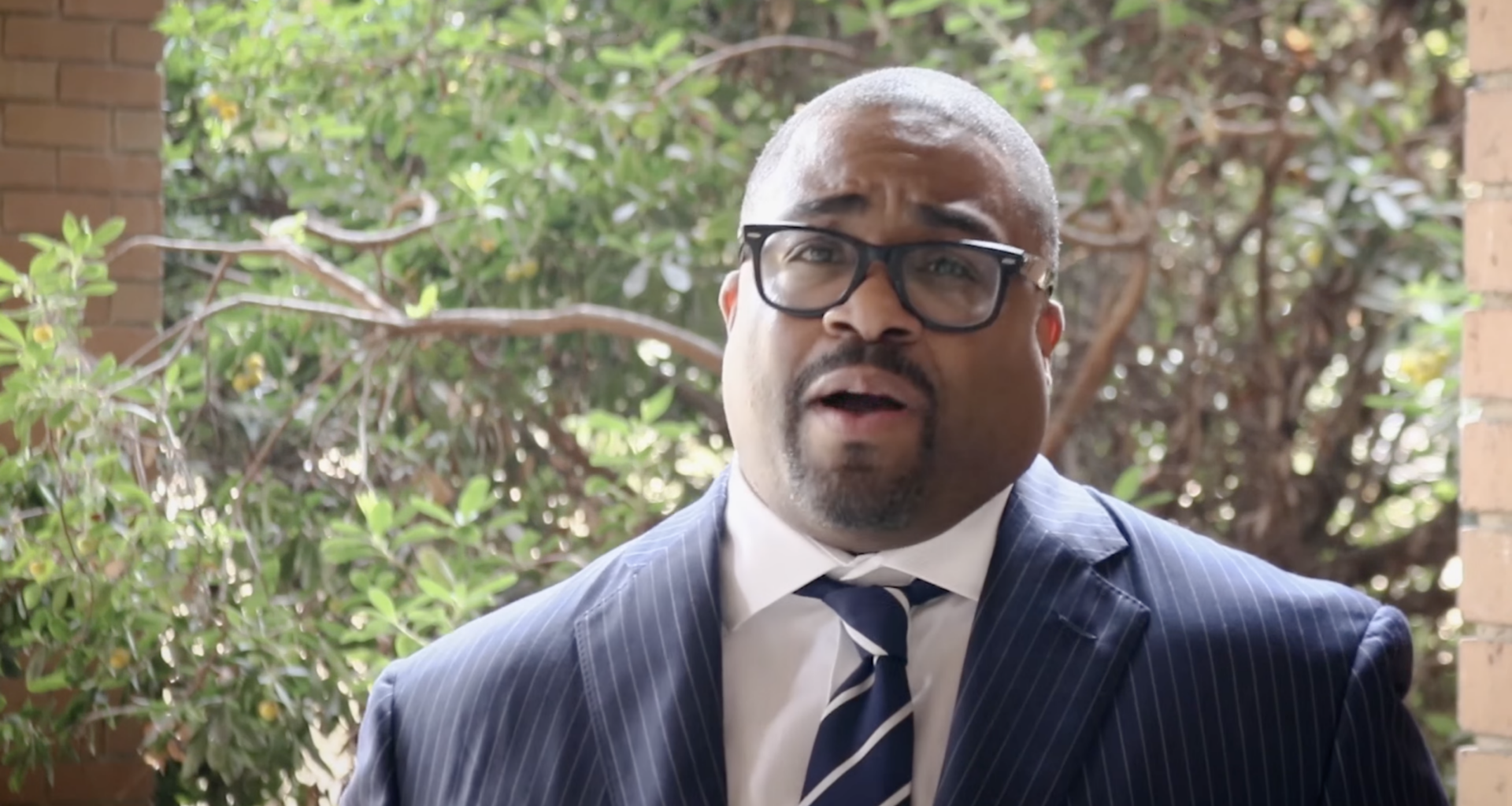 A man in glasses and a suit and tie