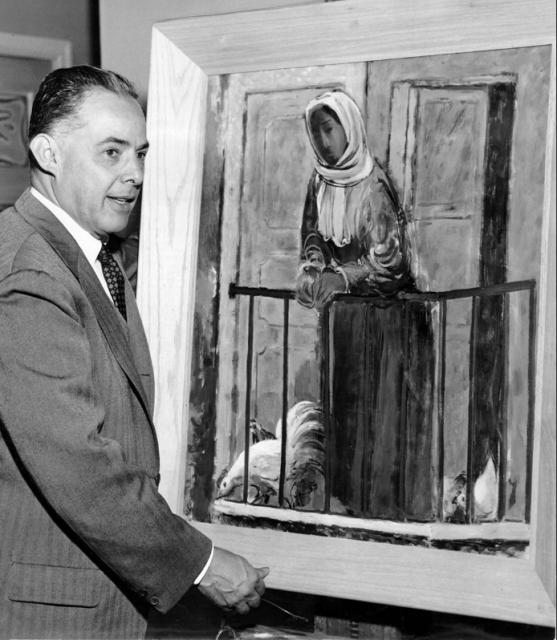 A man in a suit stands next to a framed painting of a woman in a headscarf leaning on a balcony railing with chickens below.