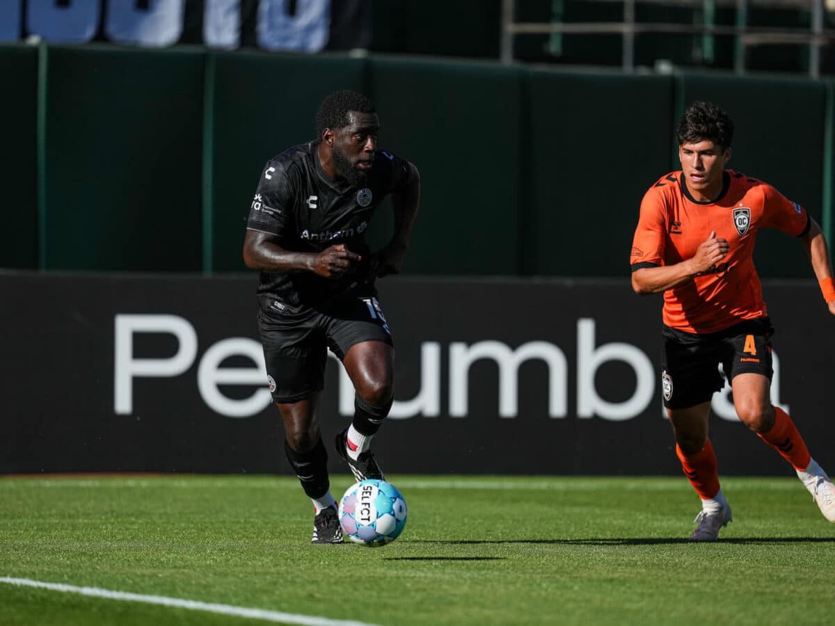 Alameda Post - An Oakland Roots player dribbles the ball in a match against Orange County SC.