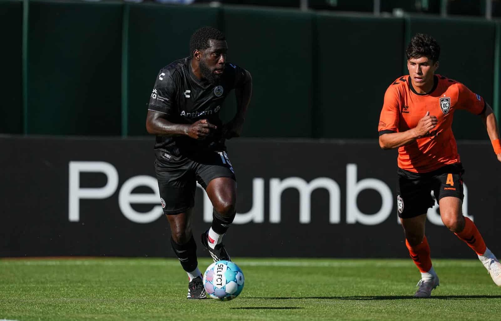 Alameda Post - An Oakland Roots player dribbles the ball in a match against Orange County SC.