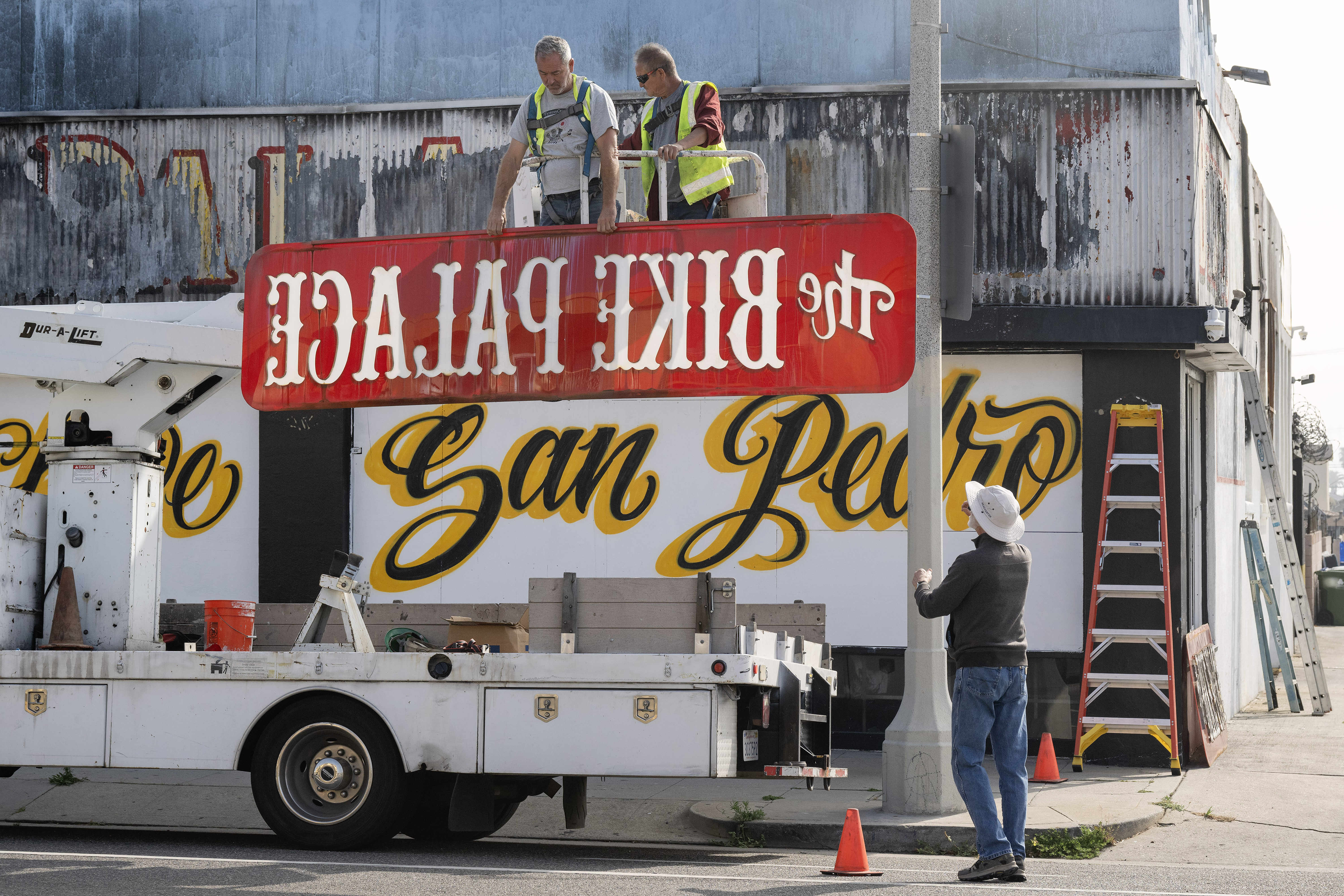 From left, Randy Weston and Tony Paze remove the iconic...