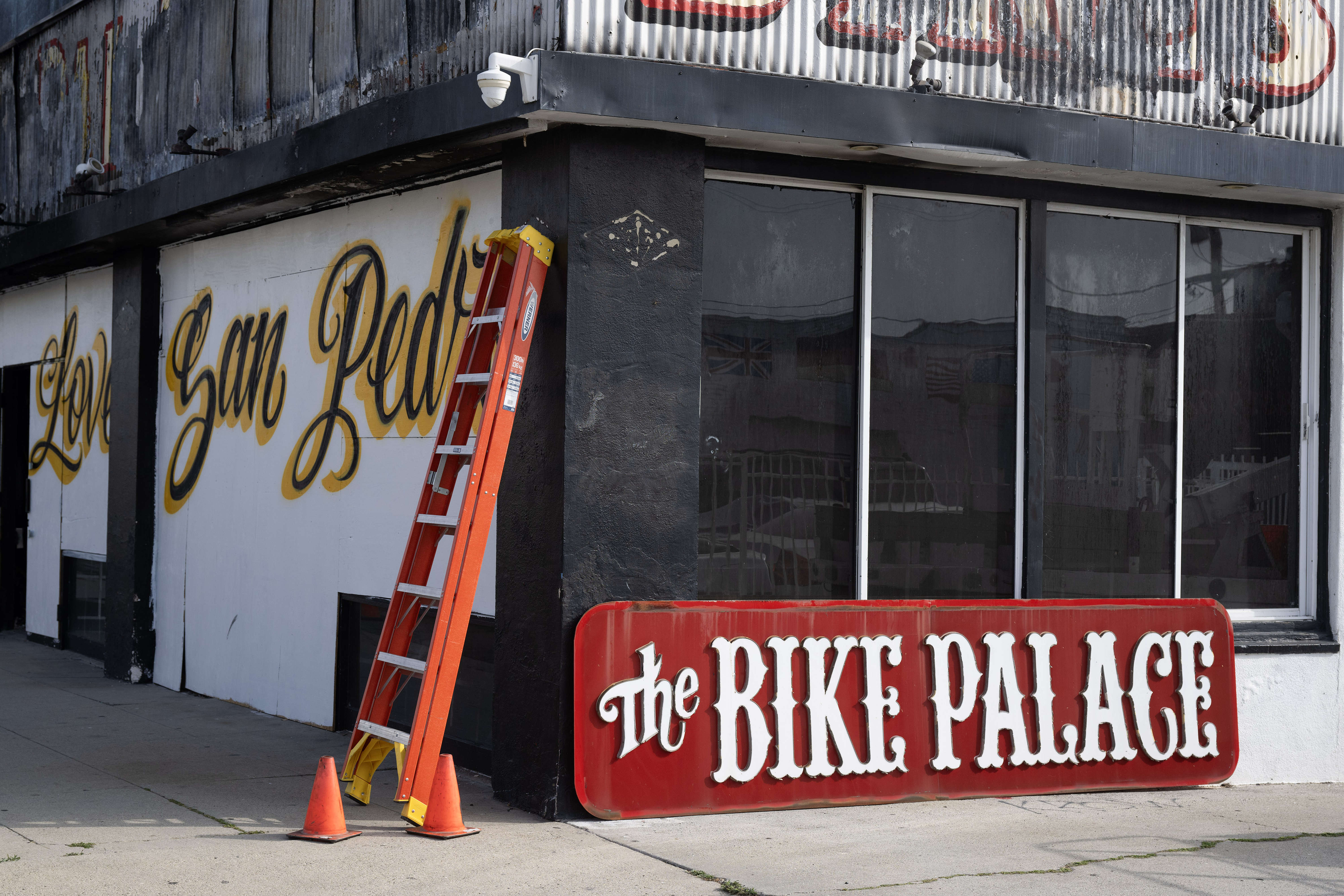 Crews work to remove the iconic Bike Palace sign on...