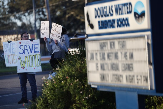 Parents hold signs in support of keeping Douglas Whited Elementary School open. Photo taken outside the school in Santa Rosa Tuesday, Jan. 13, 2026. (Beth Schlanker / The Press Democrat)