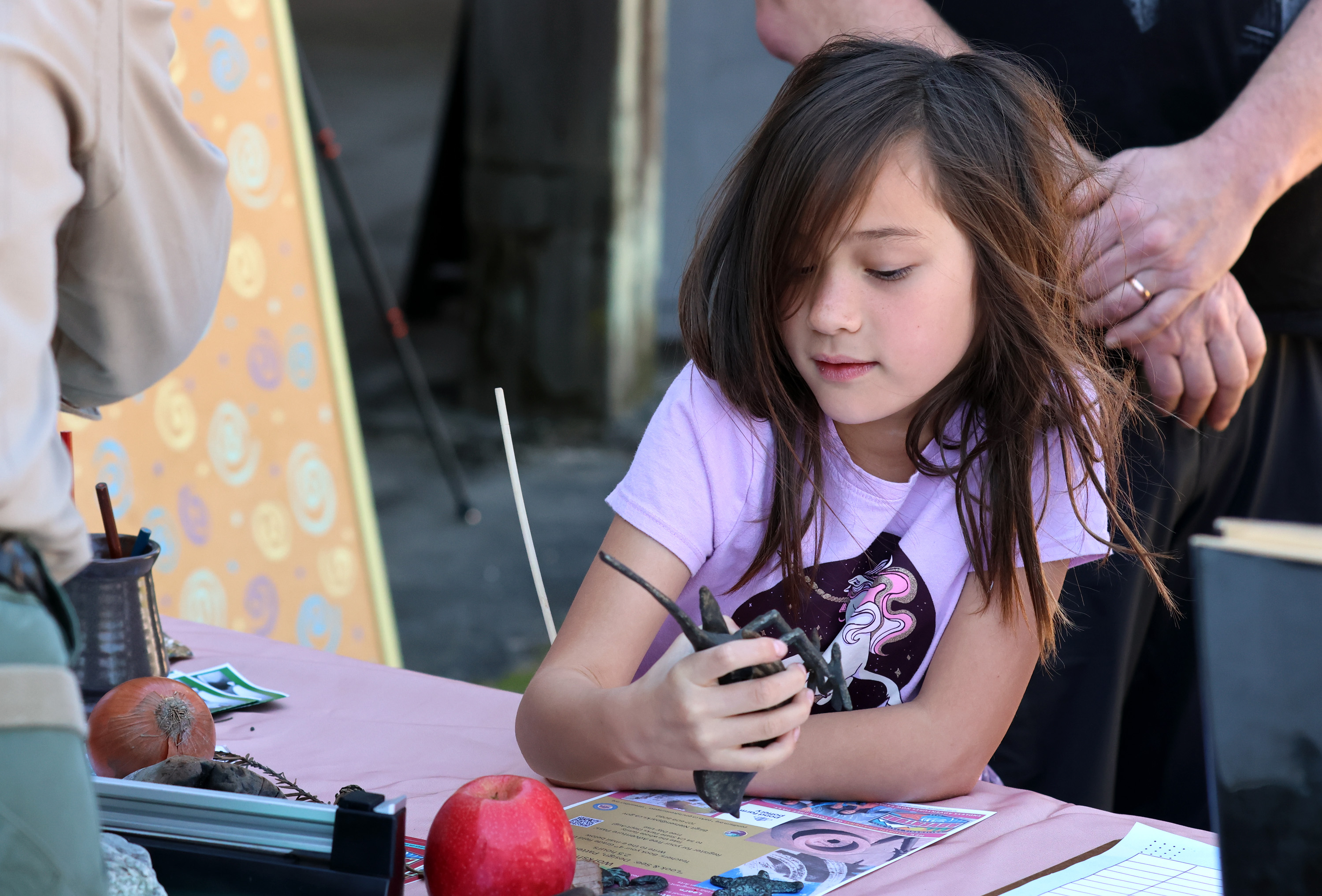 Daisy Kao Powers, 7, of Napa, looks at a figurine...