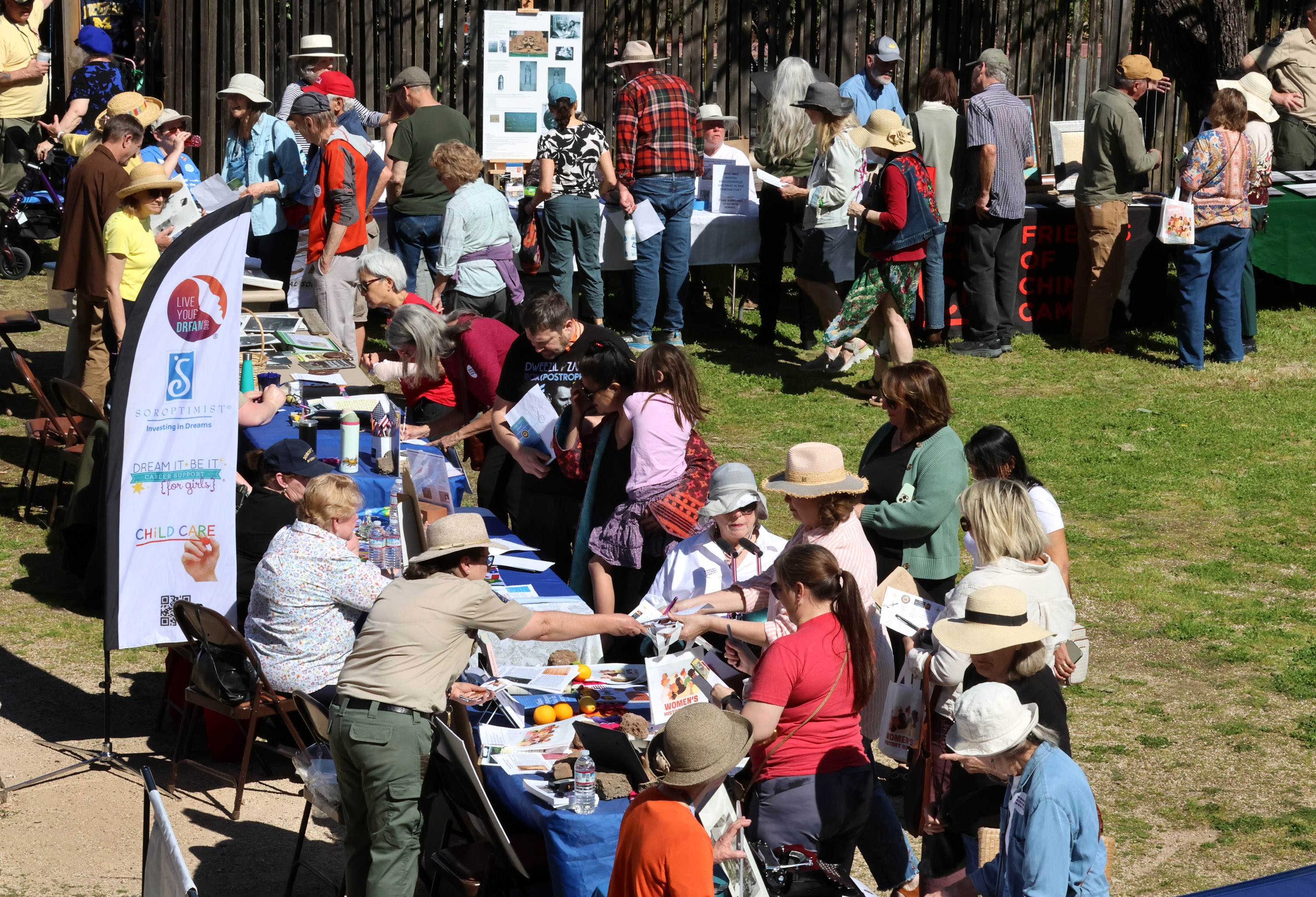 People visit tables in a circle near the barracks during...