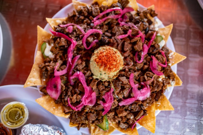 nachos with carne asada, pickled red onions, and guacamole