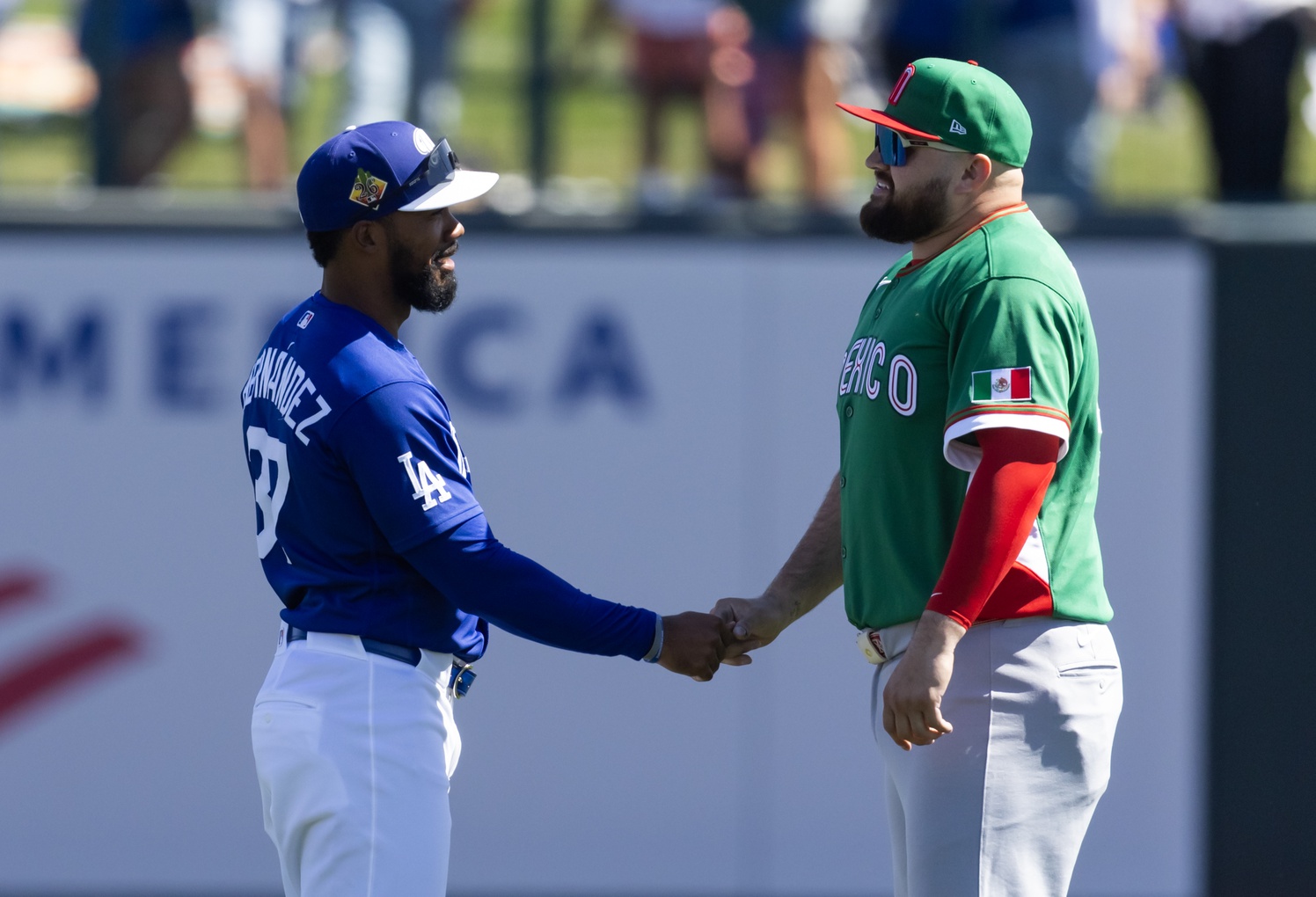 Mar 4, 2026; Glendale, AZ, USA; Team Mexico outfielder Rowdy Tellez (right) greets Los Angeles Dodgers outfielder Teoscar Hernandez during a spring training game at Camelback Ranch. Mandatory Credit: Mark J. Rebilas-Imagn Images
