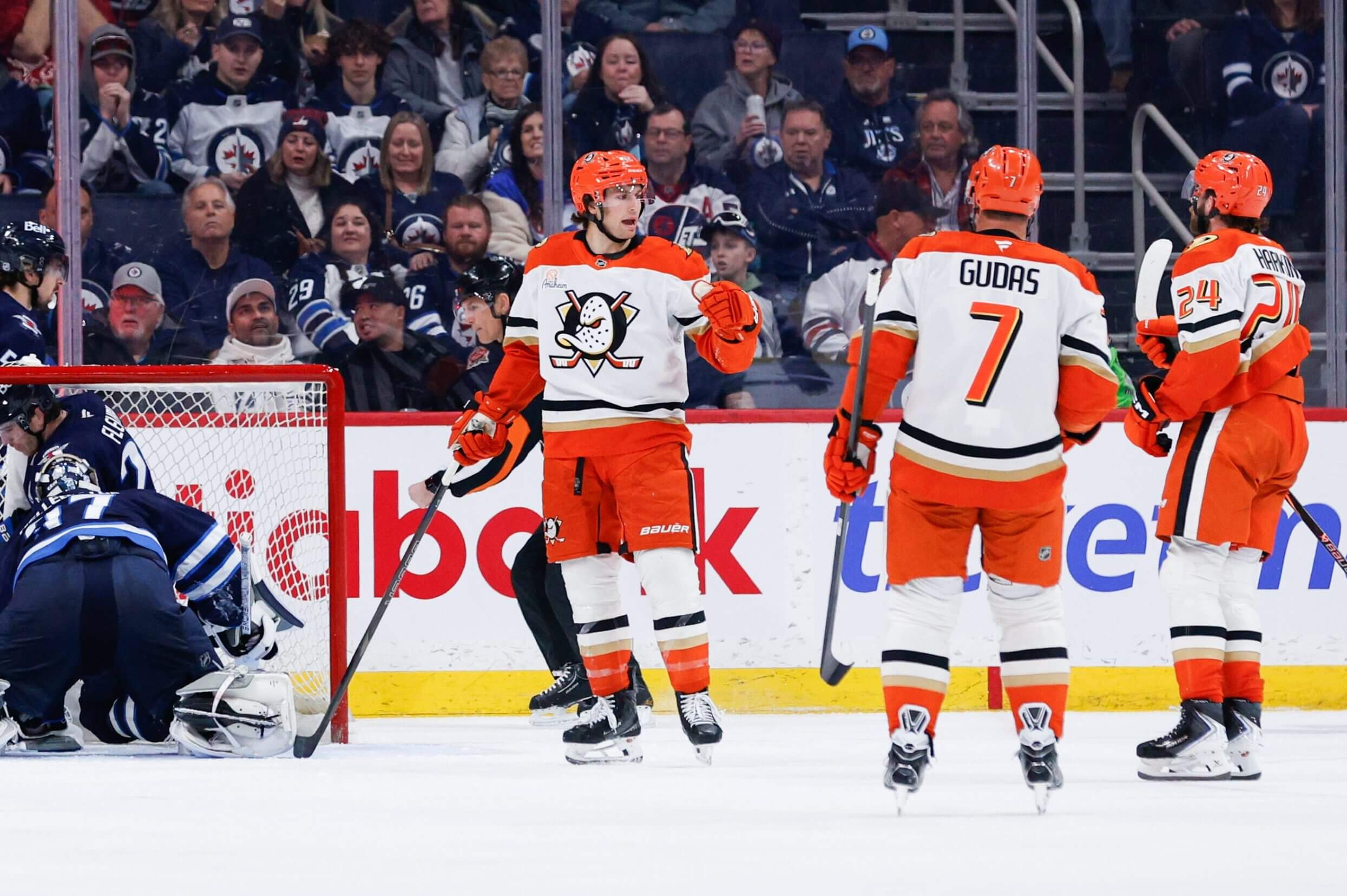 An image of Anaheim Ducks forward Tim Washe celebrating with teammates on the ice after a goal in an NHL game.