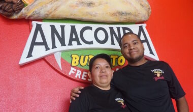 mother and son posing in front of a sign