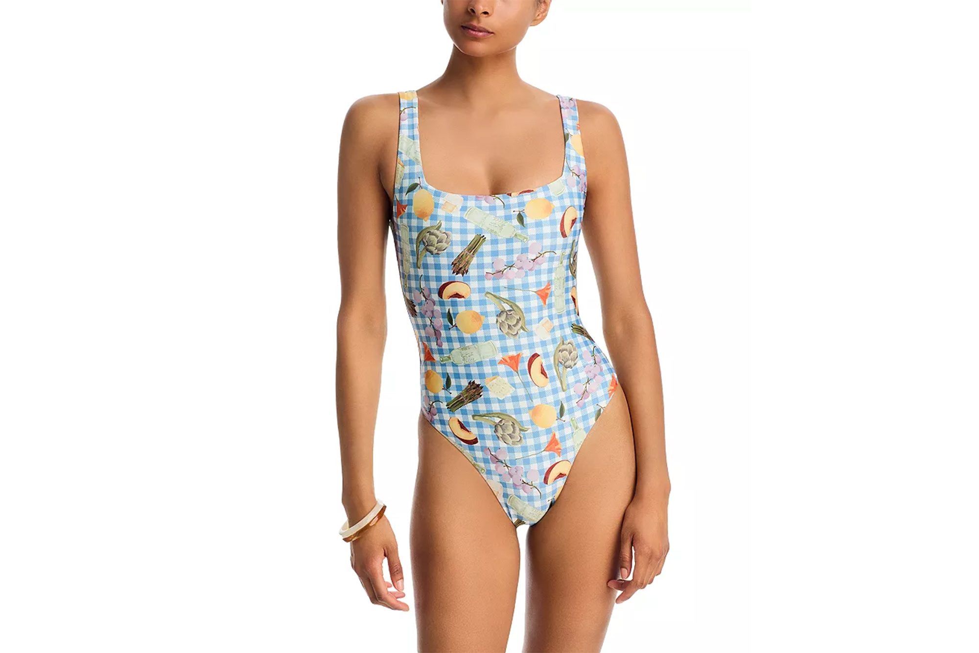 Model wearing a blue and white gingham swimsuit with fruit and vegetable illustrations.