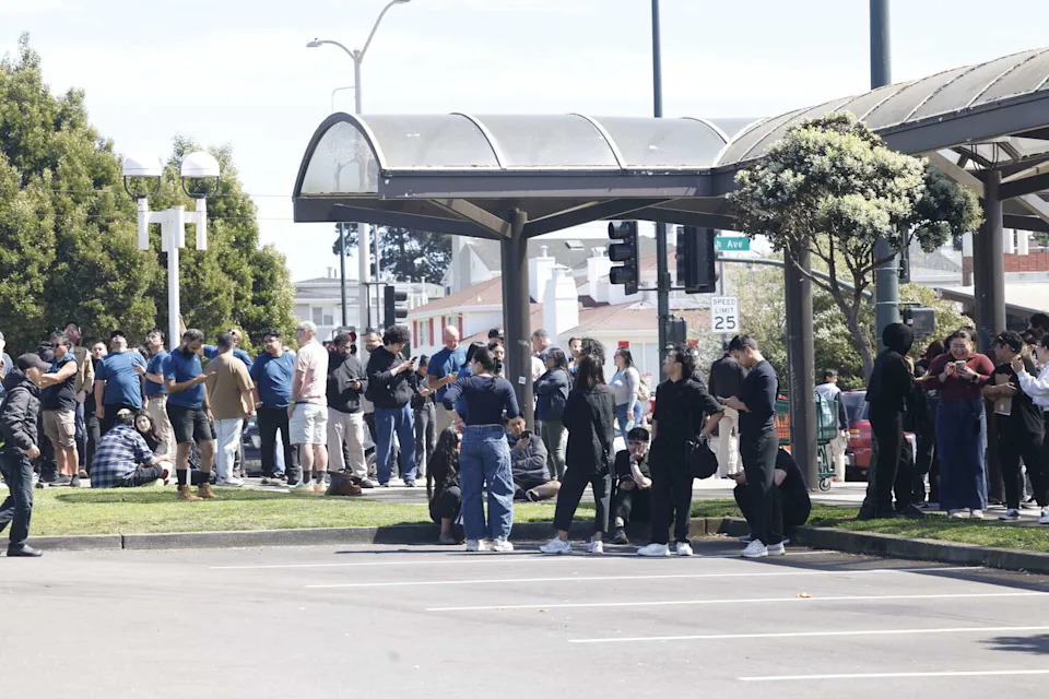 People are seen gathered in a parking lot outside of Stonestown Galleria during an evacuation on Wednesday, March 25, 2026 in San Francisco (Lea Suzuki/S.F. Chronicle)