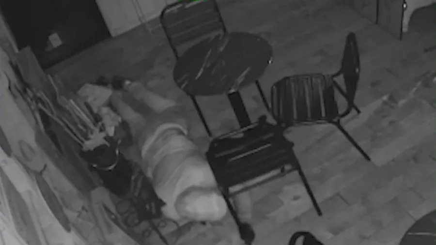 A thief crawls on his stomach to avoid motion detection sensors while robbing an adjacent jewelry store in Simi Valley. May 25, 2025.