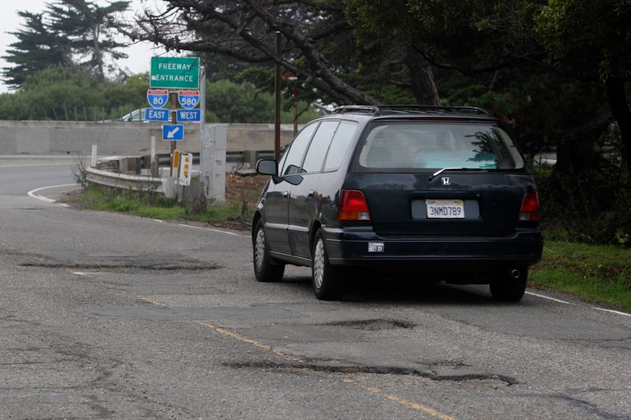 A commuter avoids a series of deep potholes on Potter Street leading to the on-ramp of eastbound I-80 on the south end of Aquatic Park in Berkeley, Calif. on Wednesday,...