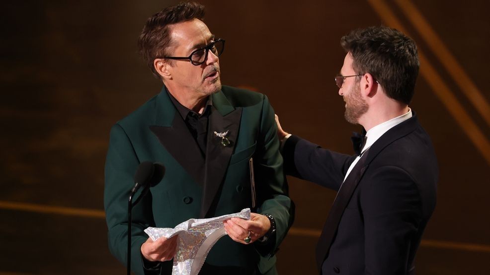 HOLLYWOOD, CALIFORNIA - MARCH 15: (L-R) Robert Downey Jr. and Chris Evans speak onstage during the 98th Oscars at Dolby Theatre on March 15, 2026 in Hollywood, California. (Photo by Kevin Winter/Getty Images)