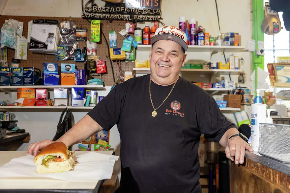 Gil Figueroa, the owner of Don Chuy's Mexi-Mercado in the Excelsior District of San Francisco, poses with his carnitas torta on Feb. 25, 2026. (Douglas Zimmerman/SFGATE)