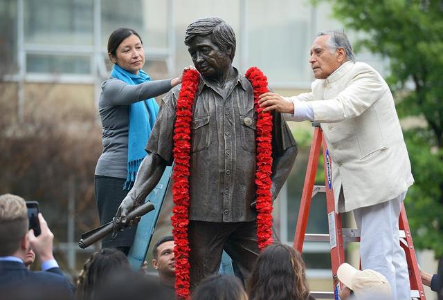 Julie Chávez Rodríguez, granddaughter of civil rights leader César E. Chávez, and Fresno State emeritus faculty member Dr. Sudarshan Kapoor, place a garland around the statue of Chávez in the Peace Garden at Fresno State in 2018.
