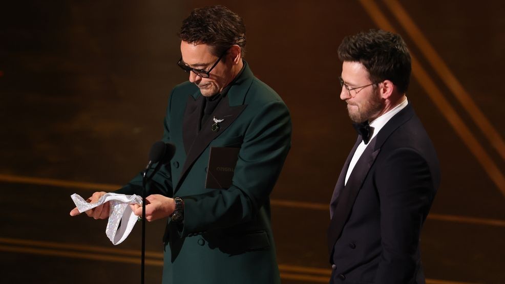 HOLLYWOOD, CALIFORNIA - MARCH 15: (L-R) Robert Downey Jr. and Chris Evans speak onstage during the 98th Oscars at Dolby Theatre on March 15, 2026 in Hollywood, California. (Photo by Kevin Winter/Getty Images)