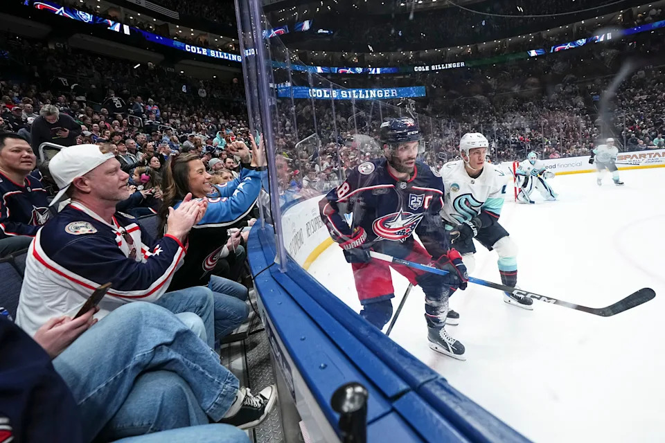 Fans cheer as Blue Jackets center Boone Jenner (38) battles for position with Kraken defenseman Ryker Evans (41) on March 21. The Blue Jackets won 5-2