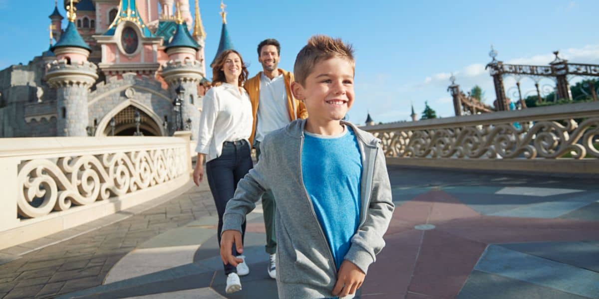 Three guests in front of Sleeping Beauty Castle at Disneyland Paris. Disney annual pass.