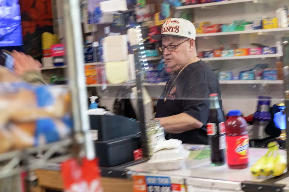 Gil Figueroa, the owner of Don Chuy's Mexi-Mercado, works behind the counter of the corner store in the Excelsior District of San Francisco on Feb. 25, 2026. (Douglas Zimmerman/SFGATE)