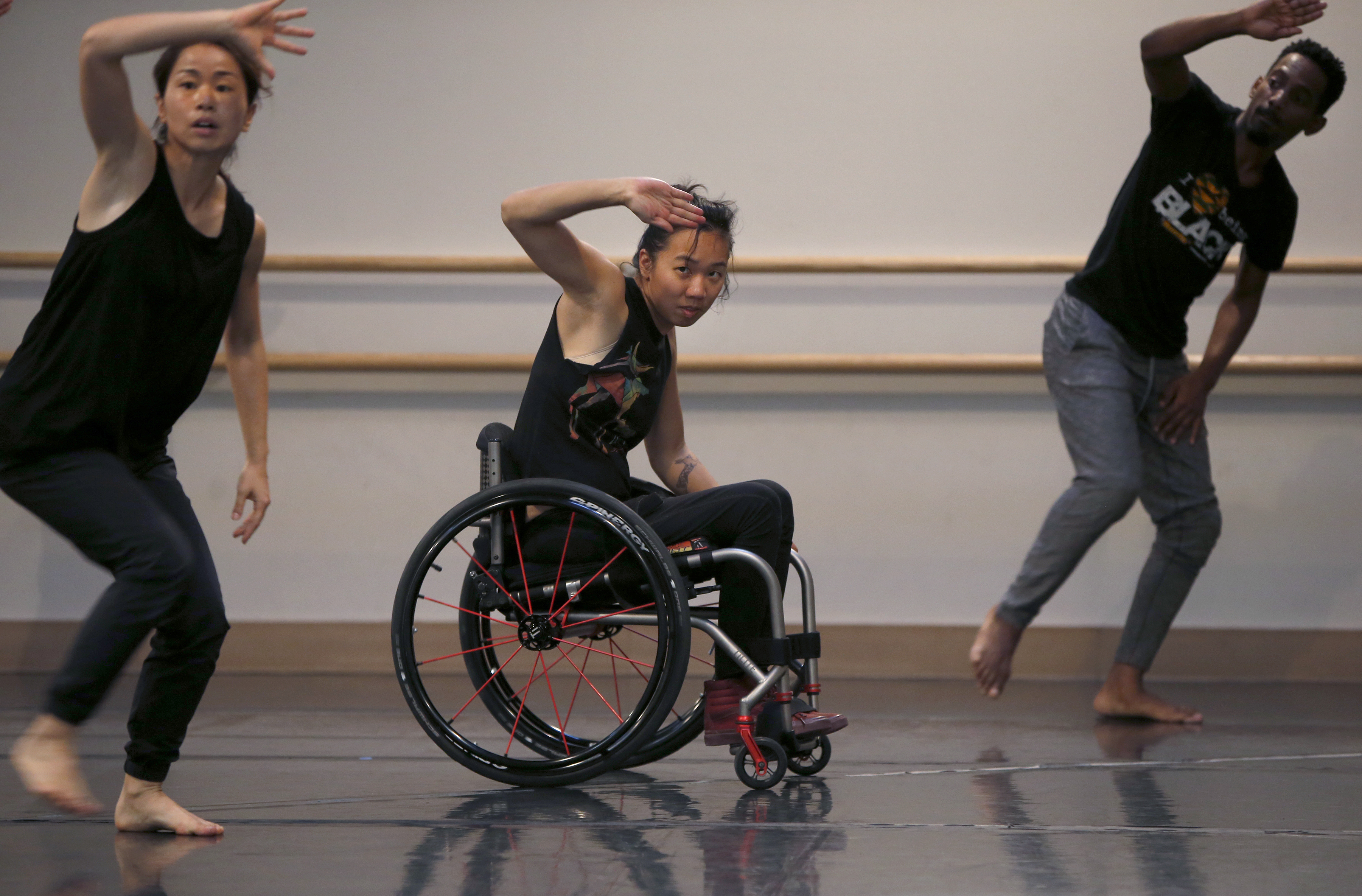 Carina Ho, center, dances in her wheelchair with Lani Dickinson...