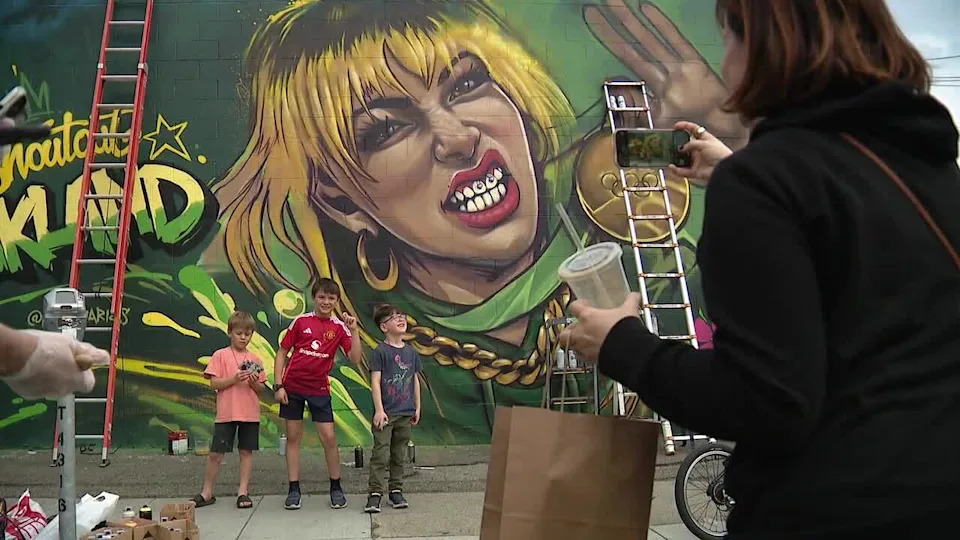 <div>A woman takes a photo of an Alysa Liu mural in Oakland's Temescal district. Feb. 28, 2026</div>