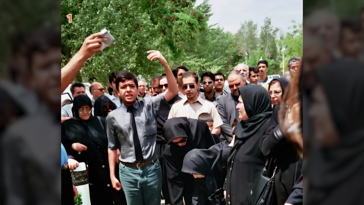 Roozbeh Farahanipour standing in crowd in Tehran