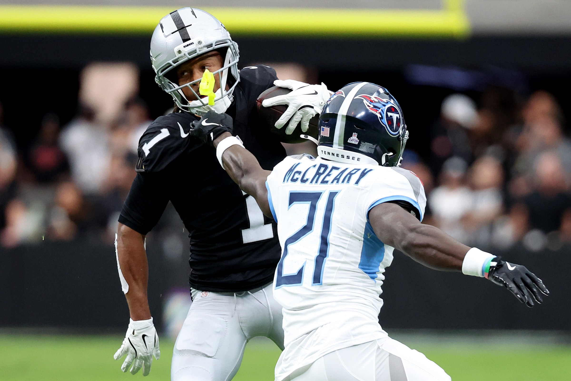 LAS VEGAS, NEVADA - OCTOBER 12: Tre Tucker #1 of the Las Vegas Raiders is grabbed by Roger McCreary #21 of the Tennessee Titans during the first quarter in the game at Allegiant Stadium on October 12, 2025 in Las Vegas, Nevada. (Photo by Ian Maule/Getty Images)