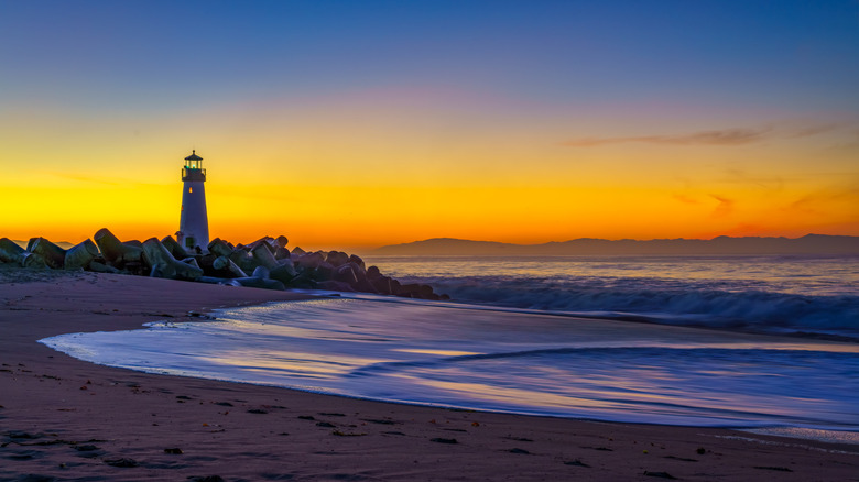 Walton Lighthouse stands on the rocks next to Seabright Beach at sunset in Santa Cruz, California.