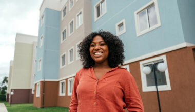 Portrait of a black woman in front of her apartment