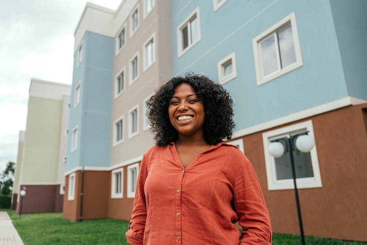 Portrait of a black woman in front of her apartment