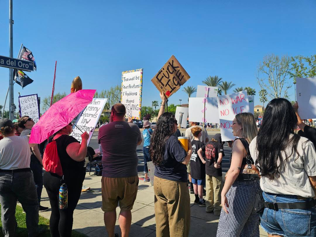 A few of the many protestors holding signs at the No Kings protest by River Park on March 28.