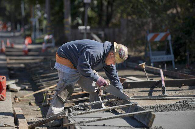 A construction worker cuts lumber while building a sidewalk along Marconi Avenue in Carmichael in 2013. Sidewalk construction projects like this are often built in phases as local agencies compete for limited state Active Transportation Program grants to fund pedestrian safety improvements.