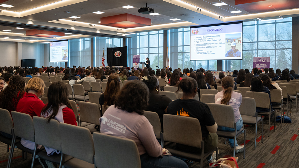 wide view of attendees watching keynote speaker on stage