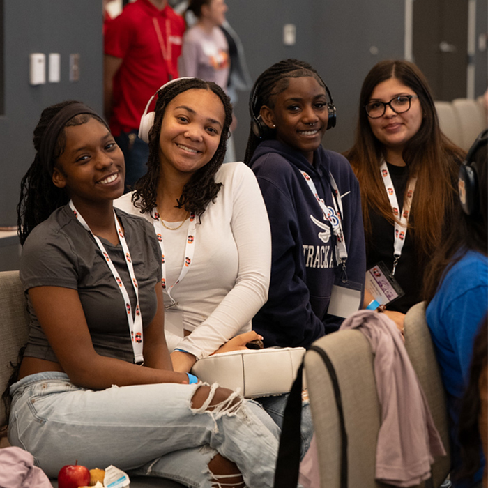 four high school girls sitting in the audience at event
