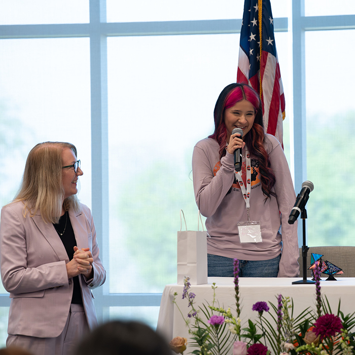 event volunteer speaking into a microphone to audience