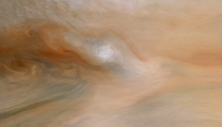 a fuzzy white patch amid reddish swirls