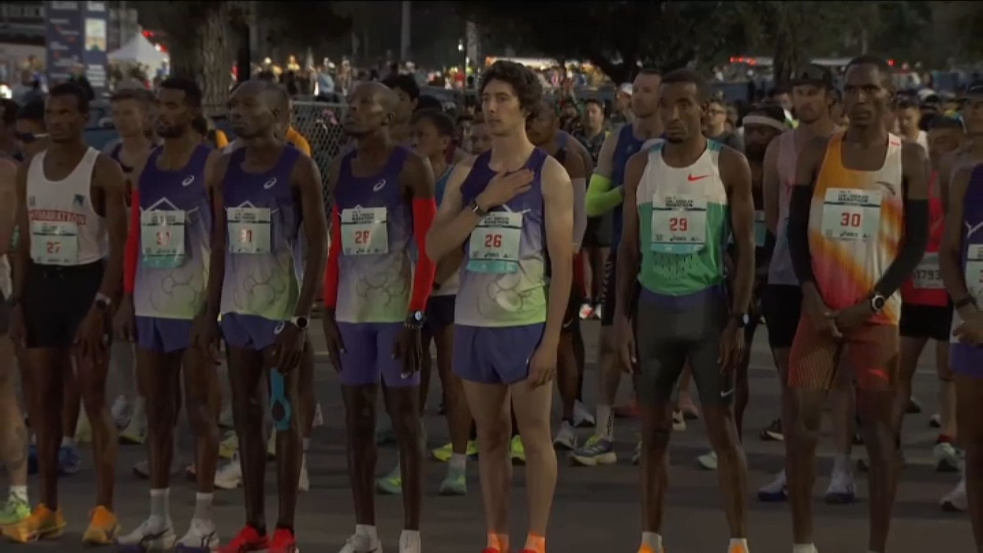 Athletes from the men’s race listen to the “Star Spangled Banner” before the big race.