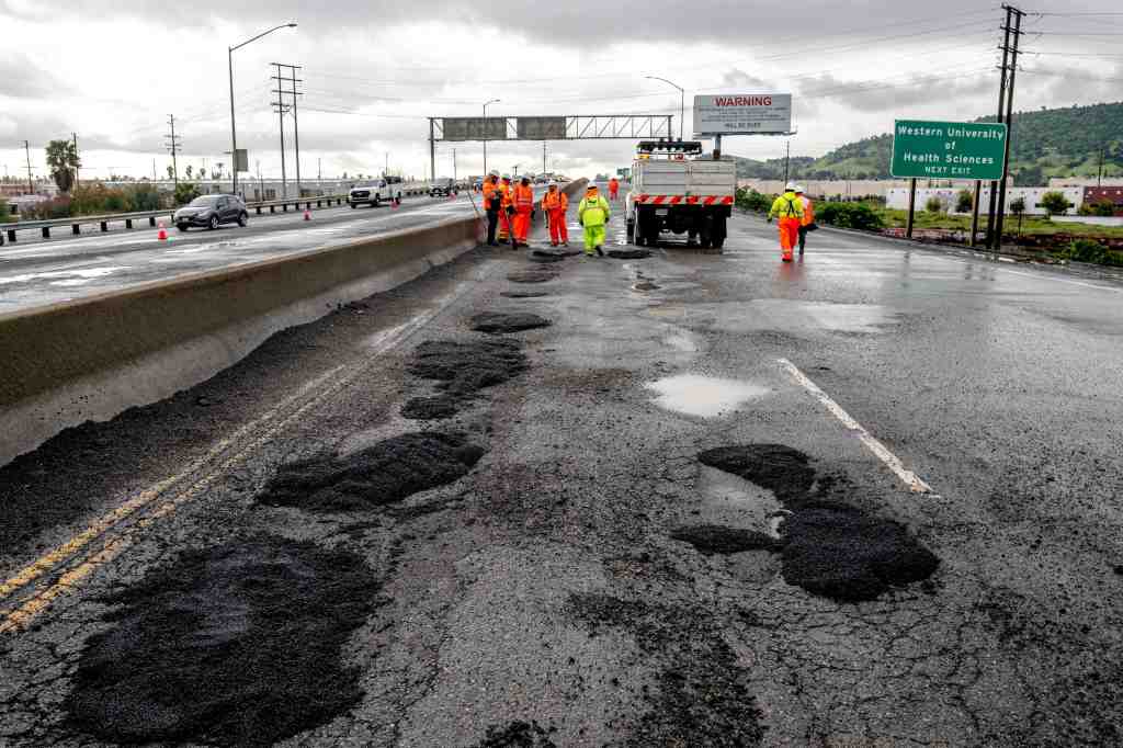 CalTrans workers repair potholes on the 71 Freeway in Pomona.