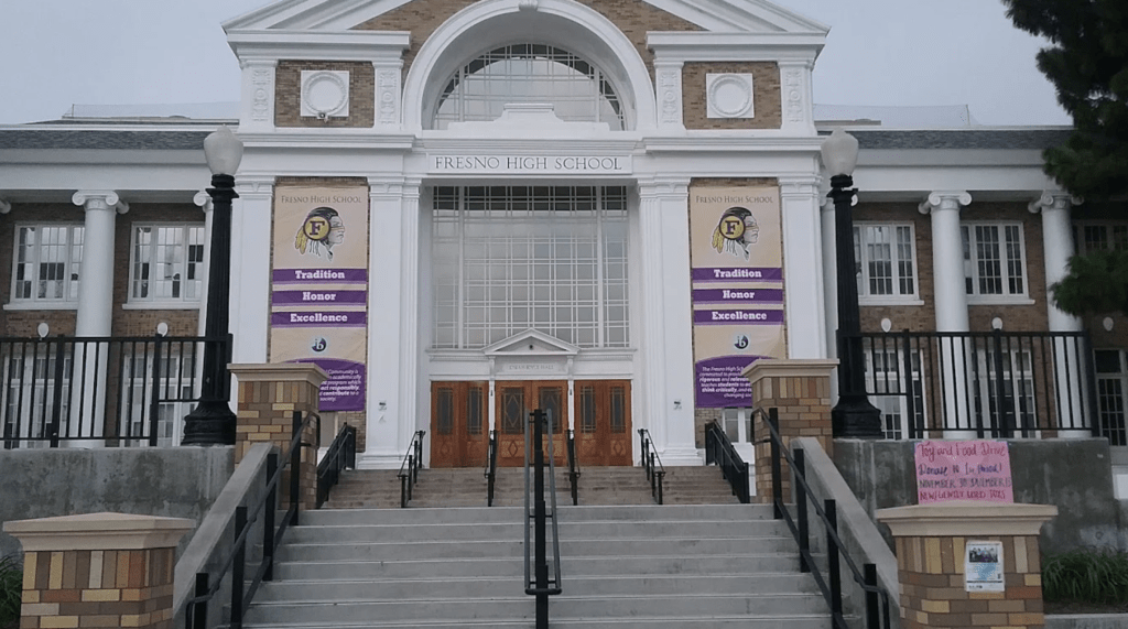 The entrance of Fresno High School, adorned with banners displaying the school's name, mascot, and motto "Tradition, Honor, Excellence."