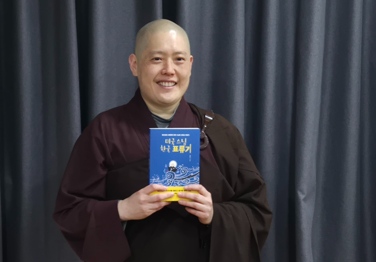 The Ven. XianAn holds her latest book, "An American Buddhist Nun’s Journey in Korea" (unofficial translation), on March 13 in central Seoul. (JF Seon Center)
