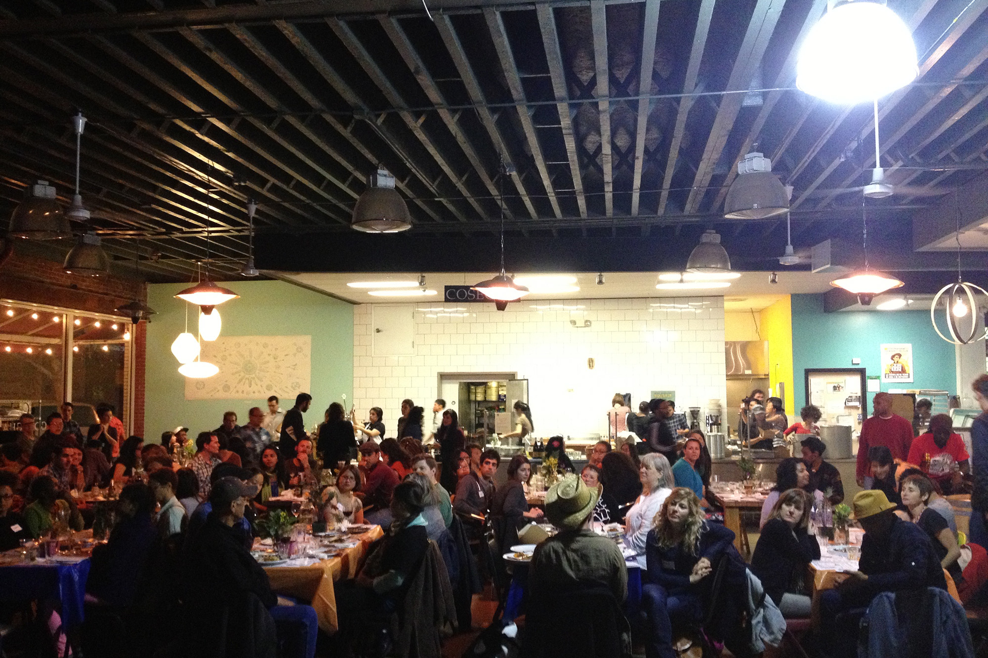 Crowded communal tables inside a food hall.