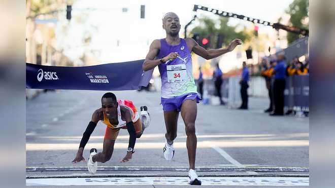 United States Nathan Martin crosses the finish line to place first with a time of 2:11:16.50 on a last-second sprint as Kenya's Michael Kimani Kamau dives and falls to the pavement during the 2026 ASICS Los Angeles Marathon in Los Angeles Sunday, March 8, 2026.