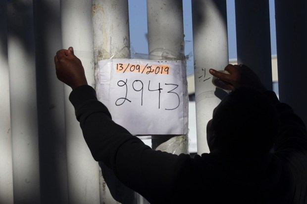 An immigrant volunteer posted the newest number sign giving the latest information as to where they are in calling the numbers that have been given out to asylum seekers over the last year so they could be taken to the U.S. for their interviews on Friday, September 13, 2019 in Tijuana, Baja California, Mexico.