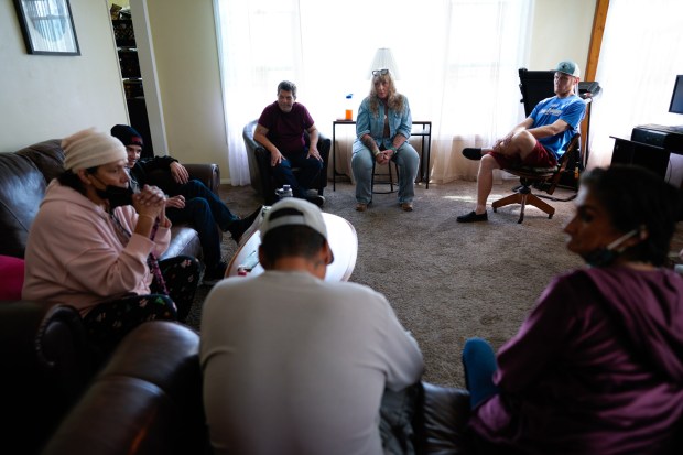 Heather Newhart (c) speaks with clients at one of her two emergency group homes in San Diego on Thursday. Many of her clients are struggling with substance abuse or have recently been released from prison. (Nelvin C. Cepeda / The San Diego Union-Tribune)